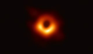 The first ever direct image of a black hole, with yellow ring surrounding black circle